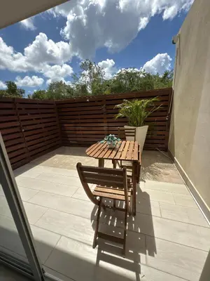 a wooden table and a chair on a patio at Blue Coast Apartment - Vibe Dominicus in La Laguna