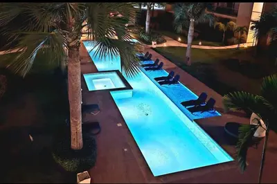 an overhead view of a swimming pool with chairs and palm trees at Blue Coast Apartment - Vibe Dominicus in La Laguna