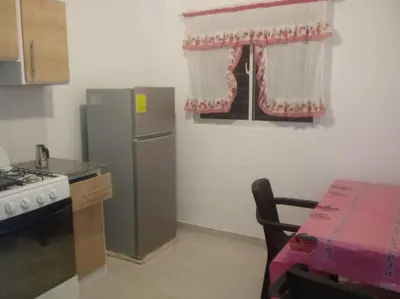 a kitchen with a refrigerator and a table and a window at Hermoso condominio con aparcamiento gratuito in La Javilla