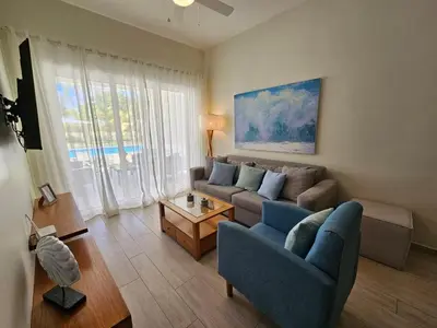 a living room with a couch and a table at Comfort Condo w/Pool View at Hard Rock Golf Course in Punta Cana