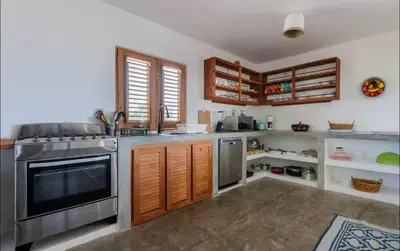 a kitchen with stainless steel appliances and wooden cabinets at Casa flor - 16 pax, vista al mar, 2 min de la playa in Las Galeras