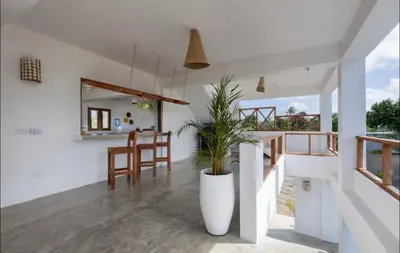 a white house with a potted plant in theoyer at Casa flor - 16 pax, vista al mar, 2 min de la playa in Las Galeras