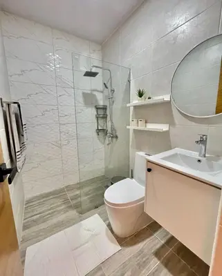 a bathroom with a toilet and a sink and a mirror at Bella Vista cozy-deluxe near Downtown center in Santo Domingo