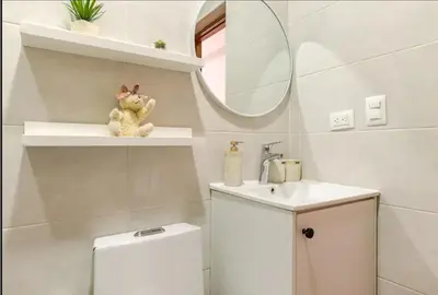 a bathroom with a toilet and a sink and a mirror at Bella Vista cozy-deluxe near Downtown center in Santo Domingo