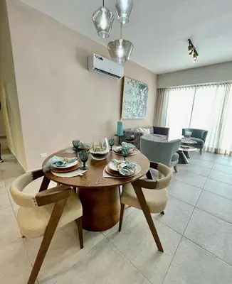a dining room table and chairs in a living room at Bella Vista cozy-deluxe near Downtown center in Santo Domingo