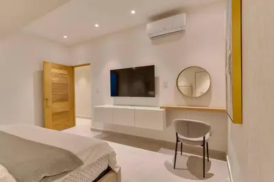 a bedroom with a bed and a tv on a wall at Oasis Urbano Family 2br Pool Gym Lm22-8B in Santo Domingo