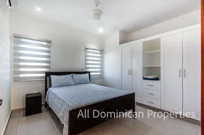 a small bedroom with a bed and white cabinets at Ocean Villas, Campo Del Mar in Sosúa