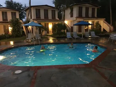 a group of people in a swimming pool at night at Casa Sylvie in Sosúa