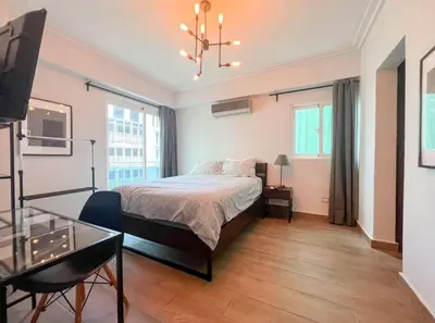 a bedroom with a bed and a glass table at Stylish 1br Apt in Piantini/Serralles, Santo Dgo in Santo Domingo