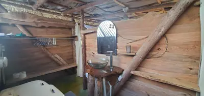 a bathroom with a wooden wall with a sink at Mini Lodge in Cabarete