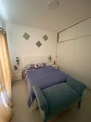 a bedroom with a bed and a blue chair at Vista Golf II Bahia Principe Playa-Nueva Romana in San Pedro de Macorís