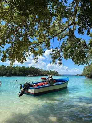 a man in a blue boat in the water at Casita Yanella in Cabrera