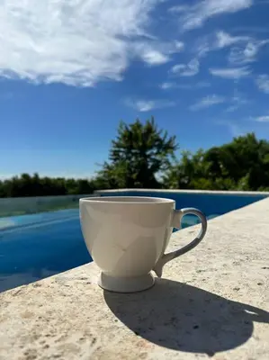 a coffee cup sitting on a table next to a pool at Casita Yanella in Cabrera