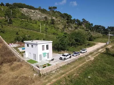 an aerial view of a white house with parked cars at Casita Yanella in Cabrera