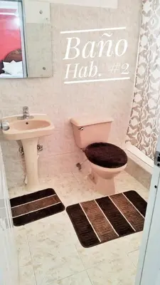a bathroom with a pink toilet and a sink at Camu in Camú