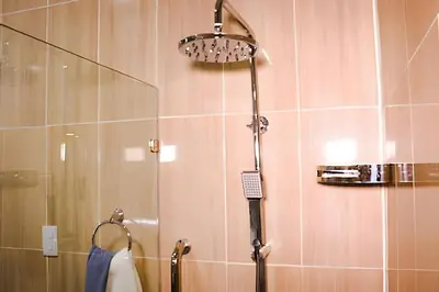 a bathroom with a shower with a light on the wall at Apart Hotel Costa Verde - #2 Exclusivo y Seguro cama King zise in Las Galeras