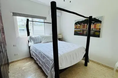 a bedroom with a four poster bed and a window at La Fenice Beachfront with King Beds in Las Terrenas