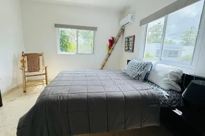 a bedroom with a large bed and two windows at La Fenice Beachfront with King Beds in Las Terrenas