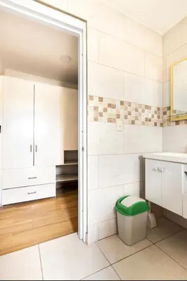 a bathroom with white cabinets and a green stool at Casa Mami in Río San Juan