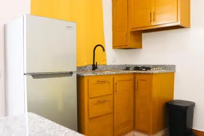 a kitchen with a white refrigerator and wooden cabinets at Apart Hotel Costa Verde#4 Exclusivo con cama Queen in Las Galeras