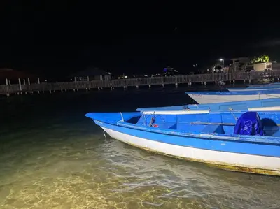 two blue boats sitting in the water at night at Casa Zanelli, lugar de paz… in Baní