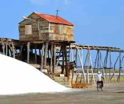 a man riding a bike in front of a wooden house at Casa Zanelli, lugar de paz… in Baní