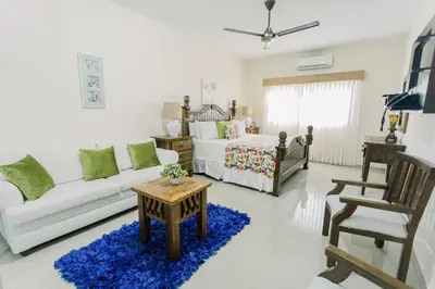 a living room with a couch and a bed at Guacamayos Hotel in Bonao