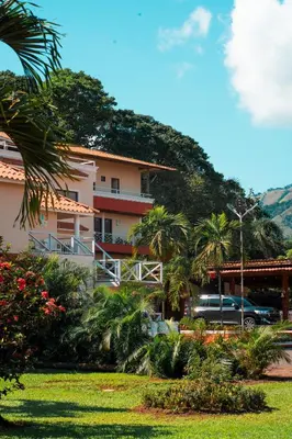 a building with a car parked in front of it at Guacamayos Hotel in Bonao