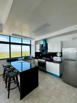 a kitchen with a refrigerator and a table with chairs at Juan Dolio, Beach Access 2 BR Apt Salitre Tower front of Club Hemingway in Juan Dolio