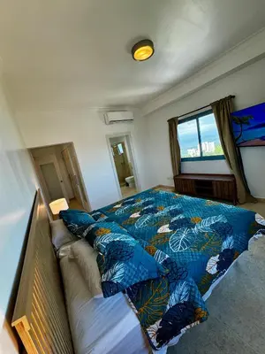 a bedroom with a bed with blue pillows on it at Juan Dolio, Beach Access 2 BR Apt Salitre Tower front of Club Hemingway in Juan Dolio