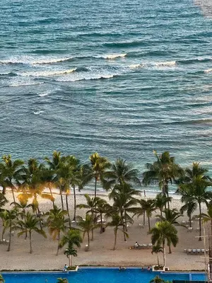 a view of a beach with palm trees and the ocean at Juan Dolio, Beach Access 2 BR Apt Salitre Tower front of Club Hemingway in Juan Dolio