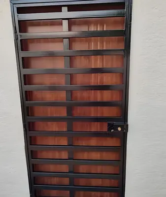 a wooden door with metal rails on a wall at Apart hotel Costa Verde #3 Exclusivo y Seguro in Santa Bárbara de Samaná