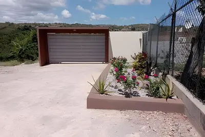 a garage door with flowers in front of it at Apart hotel Costa Verde #3 Exclusivo y Seguro in Santa Bárbara de Samaná
