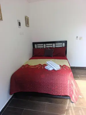 a bedroom with a red bed with red pillows at Apart hotel Costa Verde #3 Exclusivo y Seguro in Santa Bárbara de Samaná