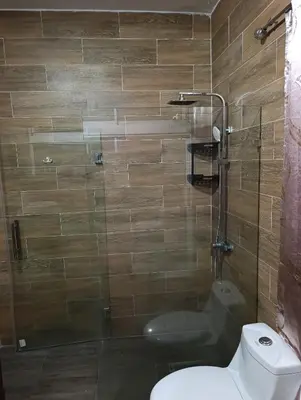 a bathroom with a toilet and a glass shower at Apart hotel Costa Verde #3 Exclusivo y Seguro in Santa Bárbara de Samaná
