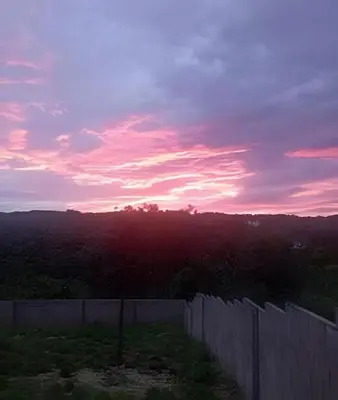 a sunset over a fence in a field at Apart hotel Costa Verde #3 Exclusivo y Seguro in Santa Bárbara de Samaná