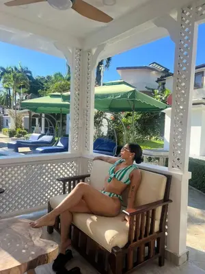 a woman sitting in a chair on a porch at Villas Carela in Cabarete