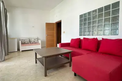 a living room with a red couch and a table at La Fenice Beachfront 3 Bedroom With Parking in Las Terrenas