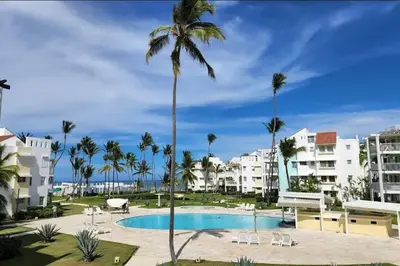 a view of a resort pool with palm trees and buildings at beautiful beachfront complex with 2 pools, free wifi, free beach chairs in Punta Cana