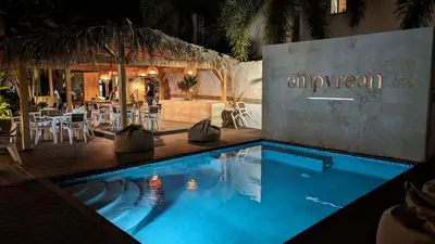 a swimming pool in front of a restaurant at night at Empyrean Tropical Wellness Portillo in Las Terrenas