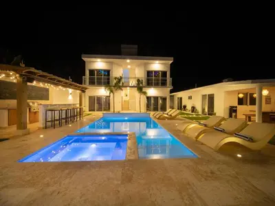a swimming pool in front of a house at night at Green Palace - 7br Luxury Villa in Sosua 3mins from strip plus 24hr security in Sosúa