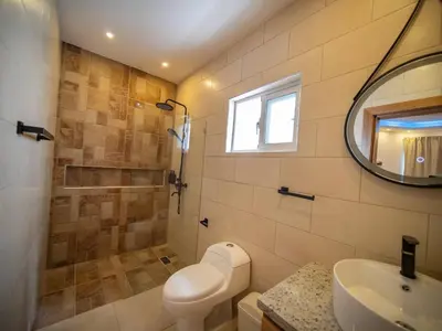 a bathroom with a toilet and a sink and a mirror at Green Palace - 7br Luxury Villa in Sosua 3mins from strip plus 24hr security in Sosúa