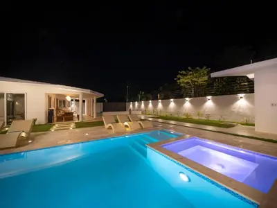 a swimming pool with blue lighting in a backyard at night at Green Palace - 7br Luxury Villa in Sosua 3mins from strip plus 24hr security in Sosúa