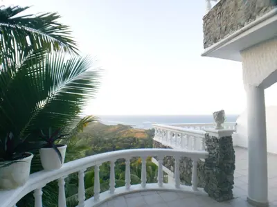 a white balcony with a view of the ocean at Immaculate 1-Bed Apartment in Cofresi in Las Flores