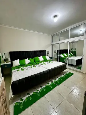 a large bedroom with a large bed with green pillows at Hotel Mi Dulce Amanecer PyR in Nagua