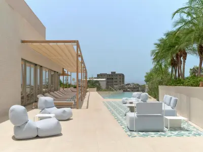 a row of white chairs and tables on the side of a building at Kimpton Las Mercedes by IHG in Santo Domingo