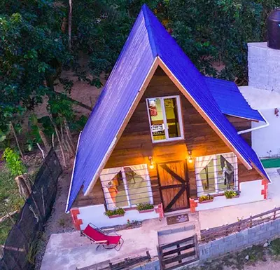 a small house with a blue roof at Canada House Queen bed in 2nd floor dbl sofa bed in 1st floor BBQ Private pool, river in Jarabacoa