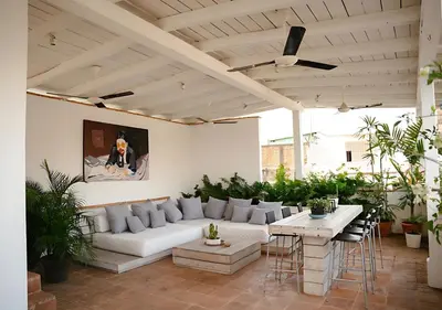 a living room with a white couch and tables and plants at Billini Hotel, Historic Luxury in Santo Domingo