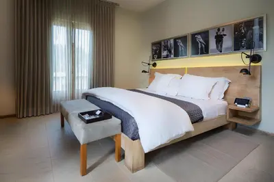 a hotel room with a large bed and a chair at Billini Hotel, Historic Luxury in Santo Domingo
