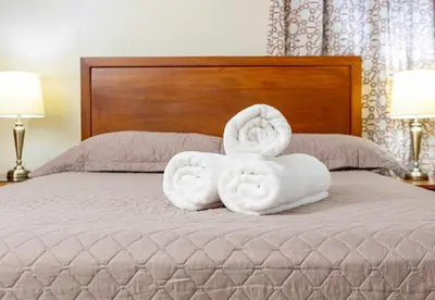 two rolls of towels sitting on top of a bed at Luxe Comfort 8 Bedroom Villa with Private Pool & Entertainment in Sosúa